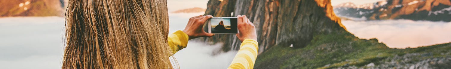 Kvinna fotograferar med mobil.